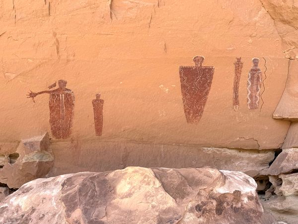 The full Hitchhiker panel: tapering painted figures along a sandstone wall