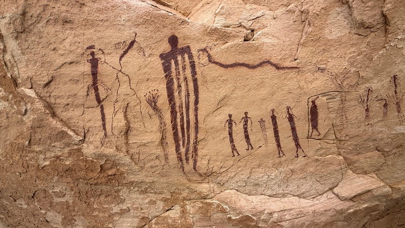 Horned snake with arms dripping from its mouth, beside striped and bird-like figures