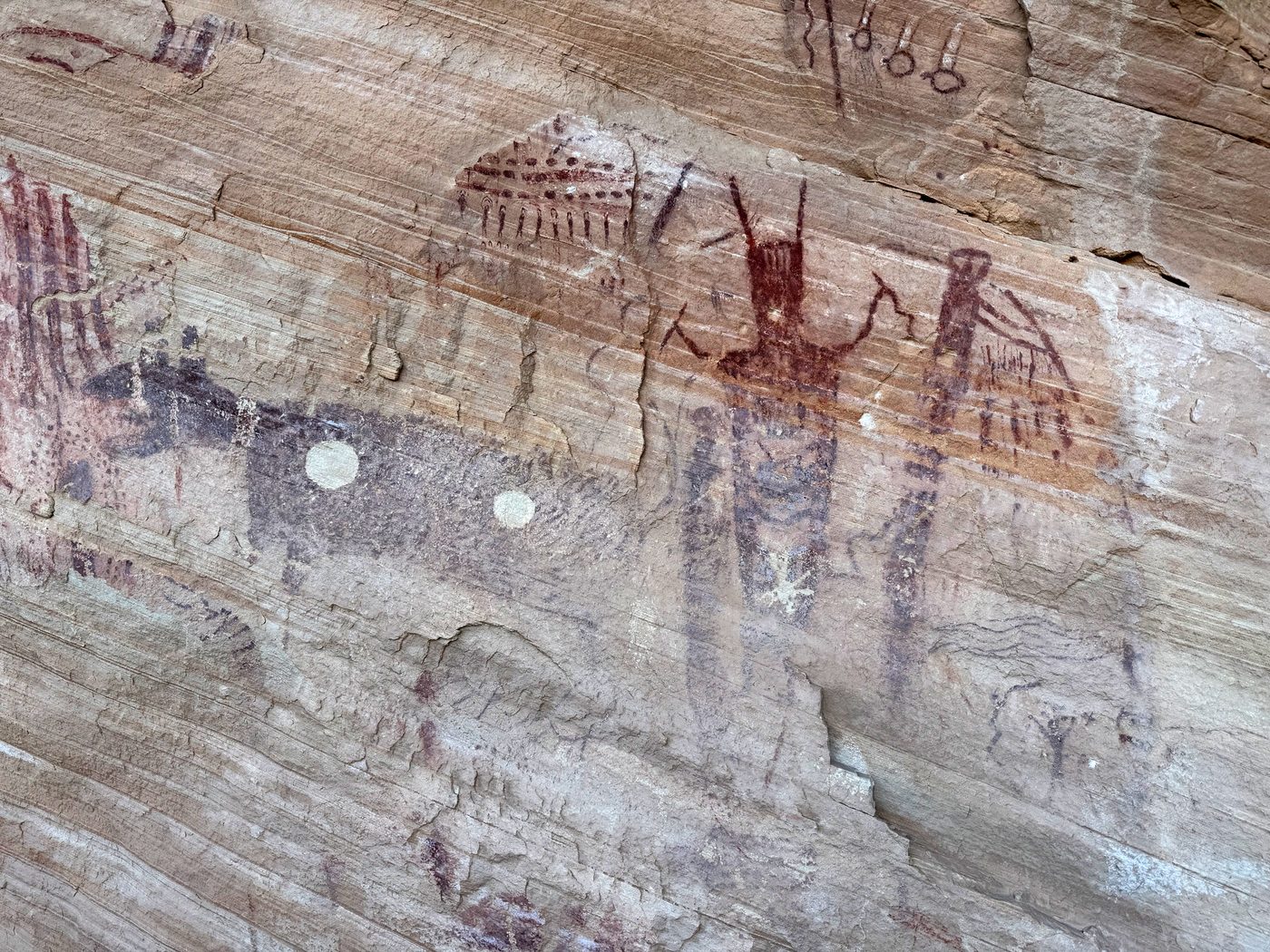 Painted anthropomorphic figures on a sandstone wall