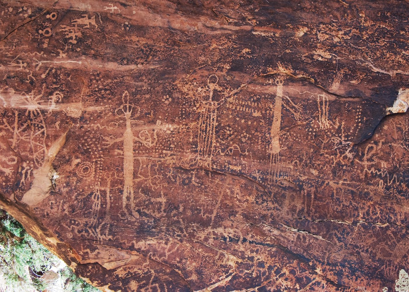 Long thin anthropomorphic figures on the side of a rock