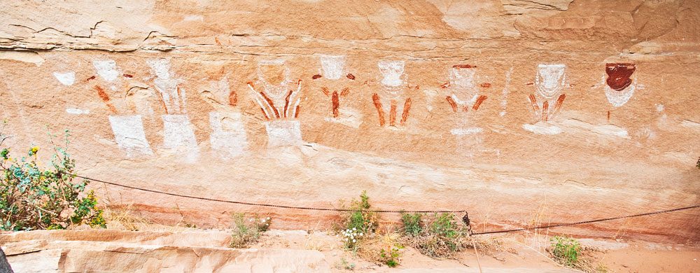 The Thirteen Faces panel: a row of painted faces above the canyon floor