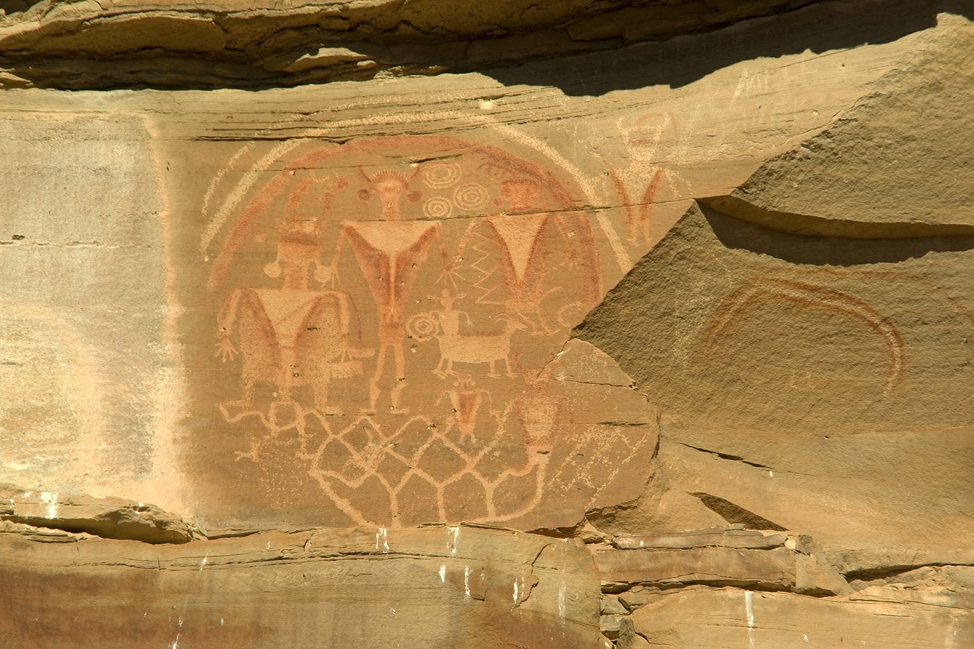 Ancestral Puebloan petroglyph panel above a river