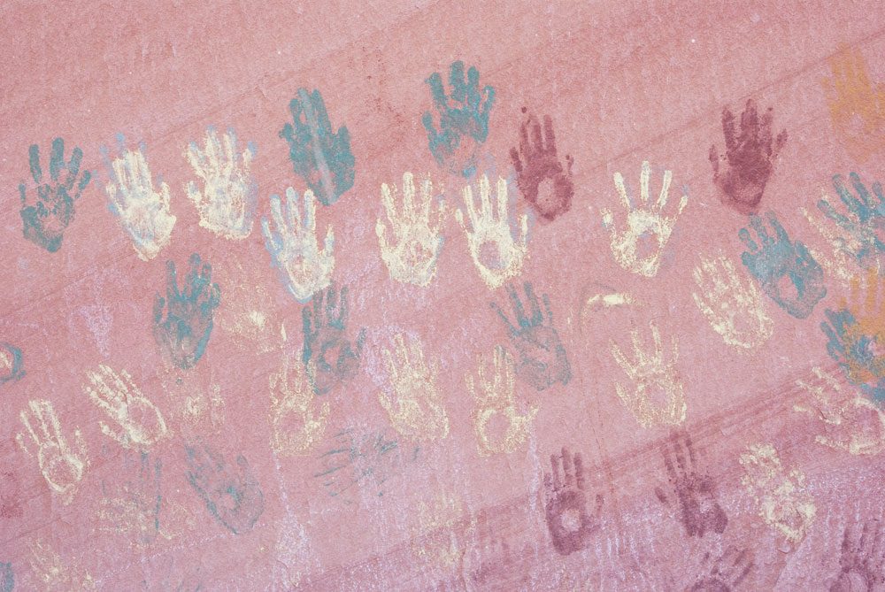 Stamped handprints in green, yellow and red