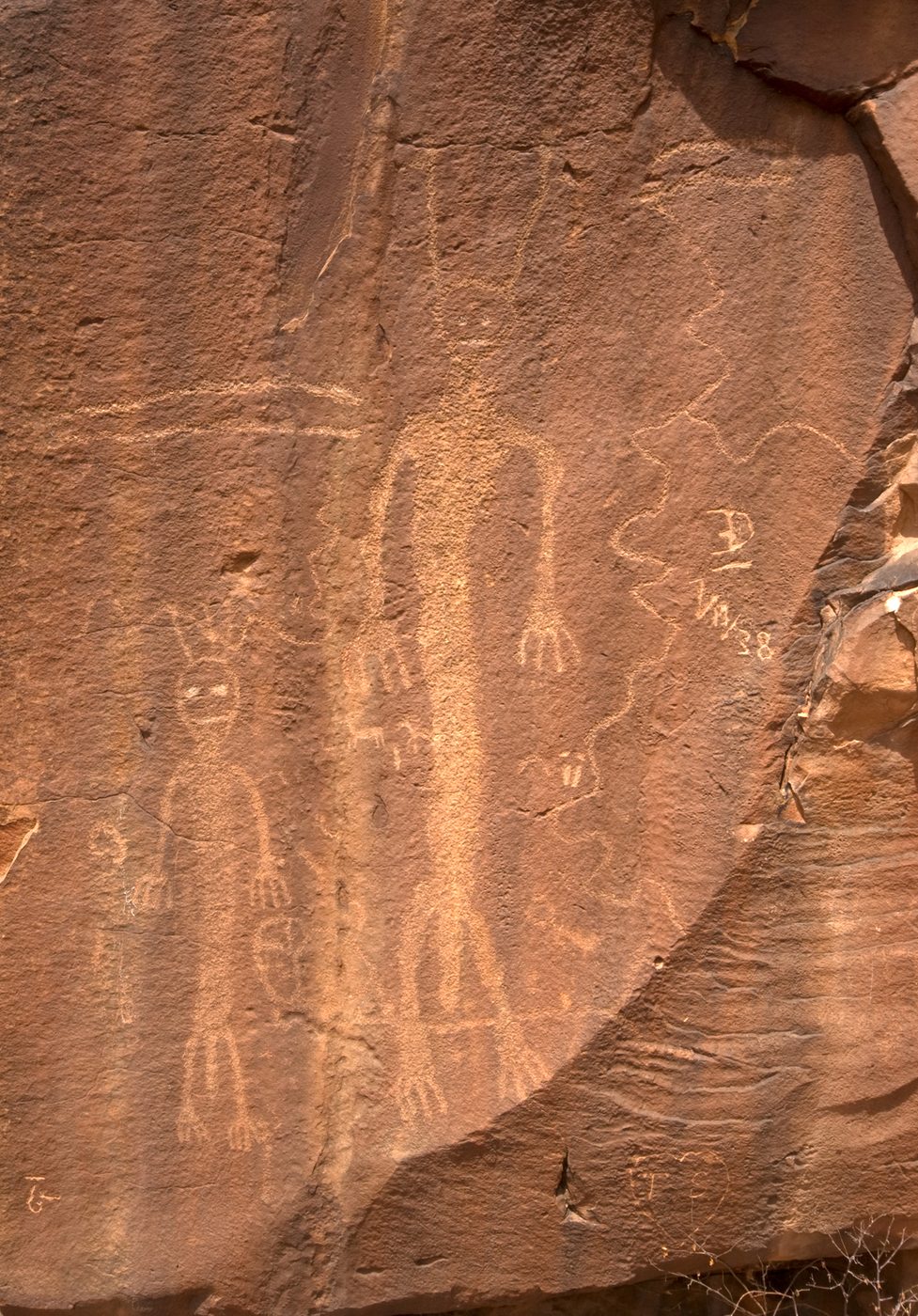 Large pecked anthropomorphic figures on a sandstone wall