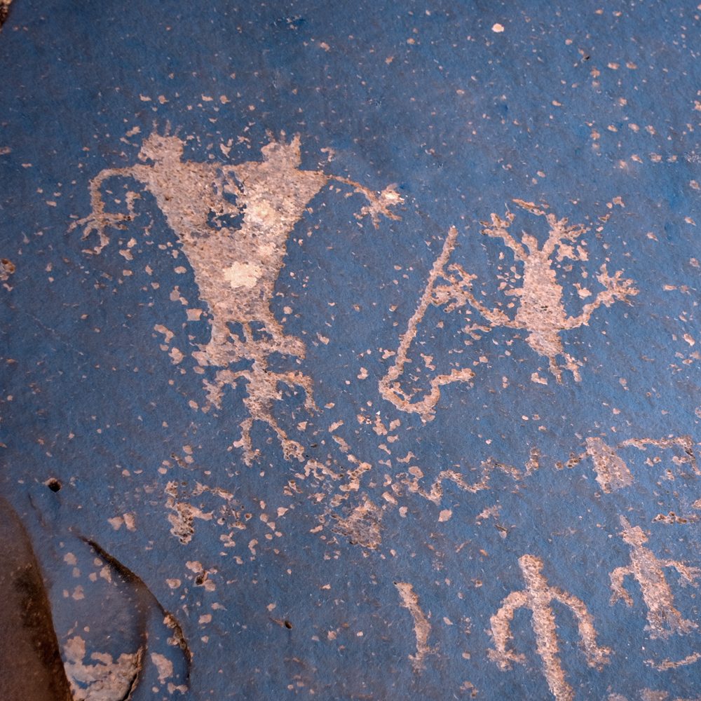Petroglyph tableau of coupling, birth, an upside-down figure and a figure with a cane