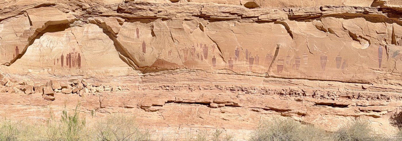 Panorama of the Great Gallery: a long row of painted figures along the base of a sandstone cliff