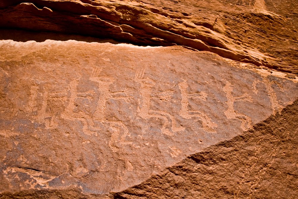 Row of twin figures pecked into the rock