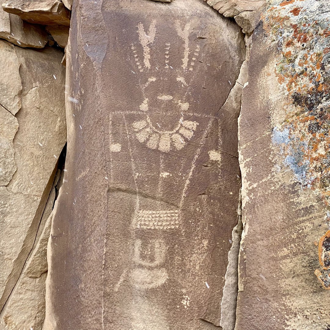 Fremont petroglyph figure with a horned headdress, a large beaded necklace and a belt
