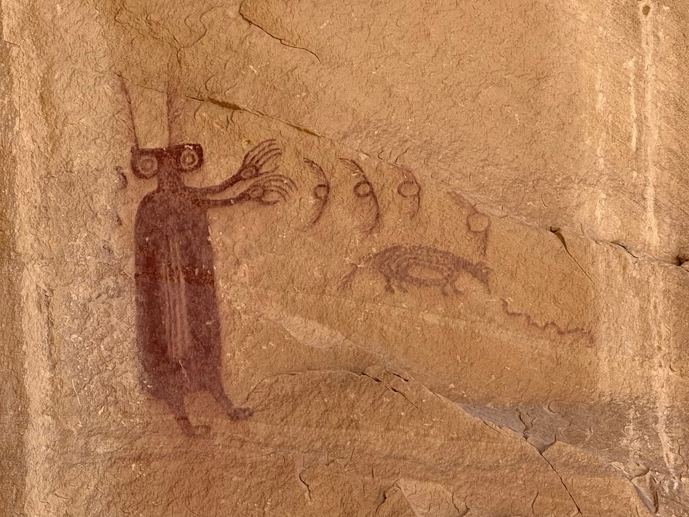 Barrier Canyon Style figure with long fingers and feathered head, birds and a four-legged animal