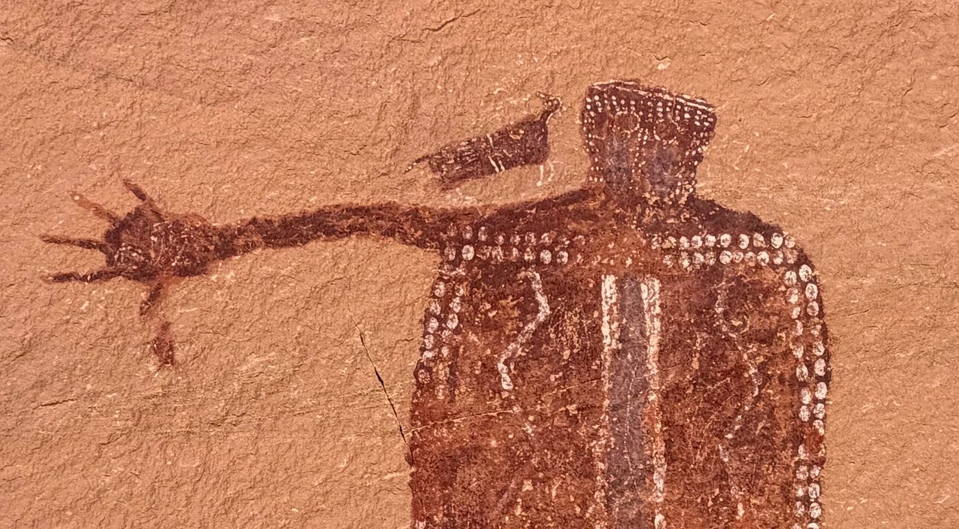 Large Barrier Canyon Style figure decorated with white dots, with one arm outstretched toward a bird