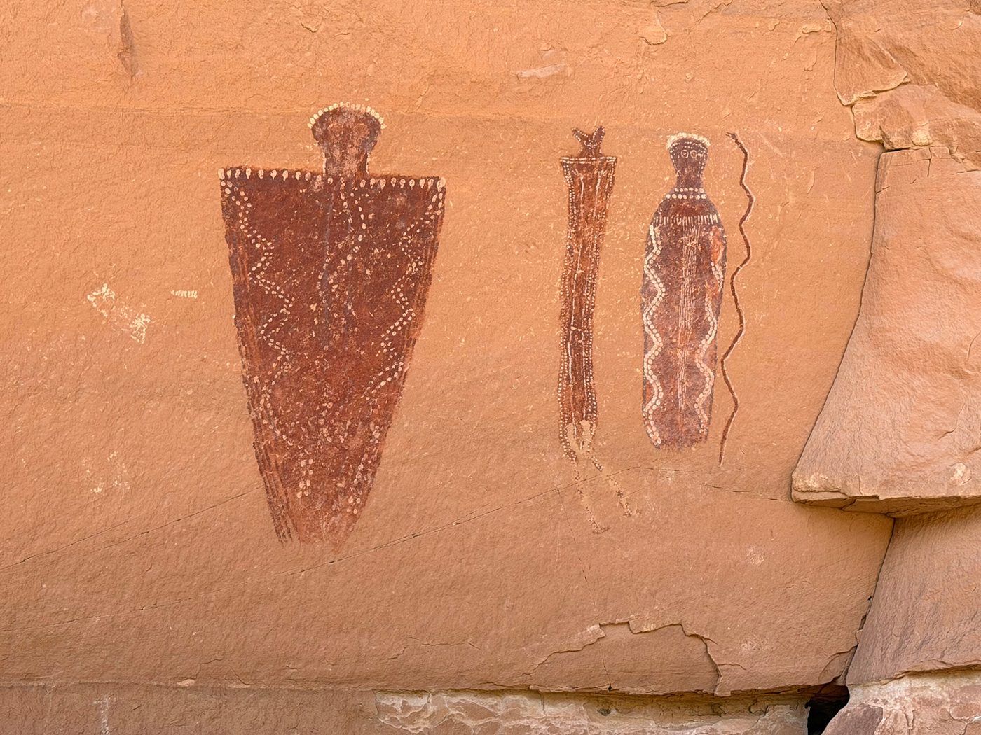 Tapering Barrier Canyon Style figures decorated with white dots and zigzag patterns