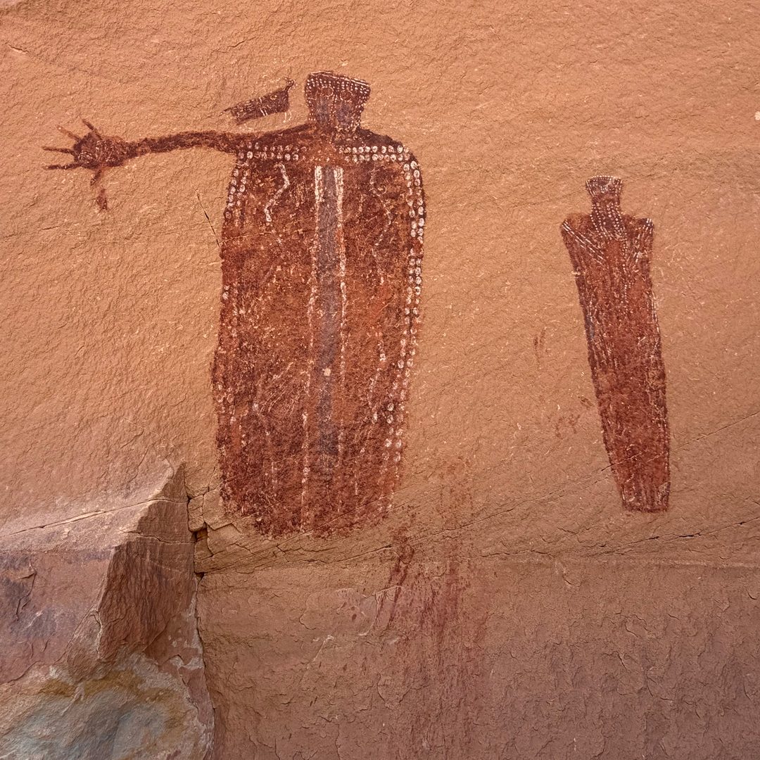 Close view of the two left figures, with red paint running below them