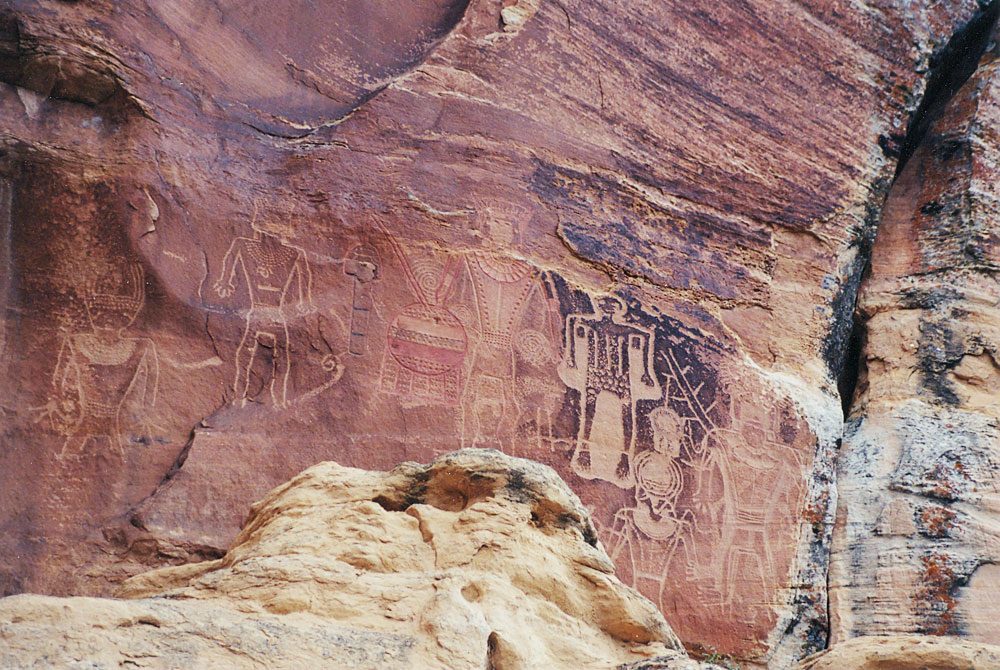 Fremont figures holding a fringed shield, with a dark skeletal figure in low relief